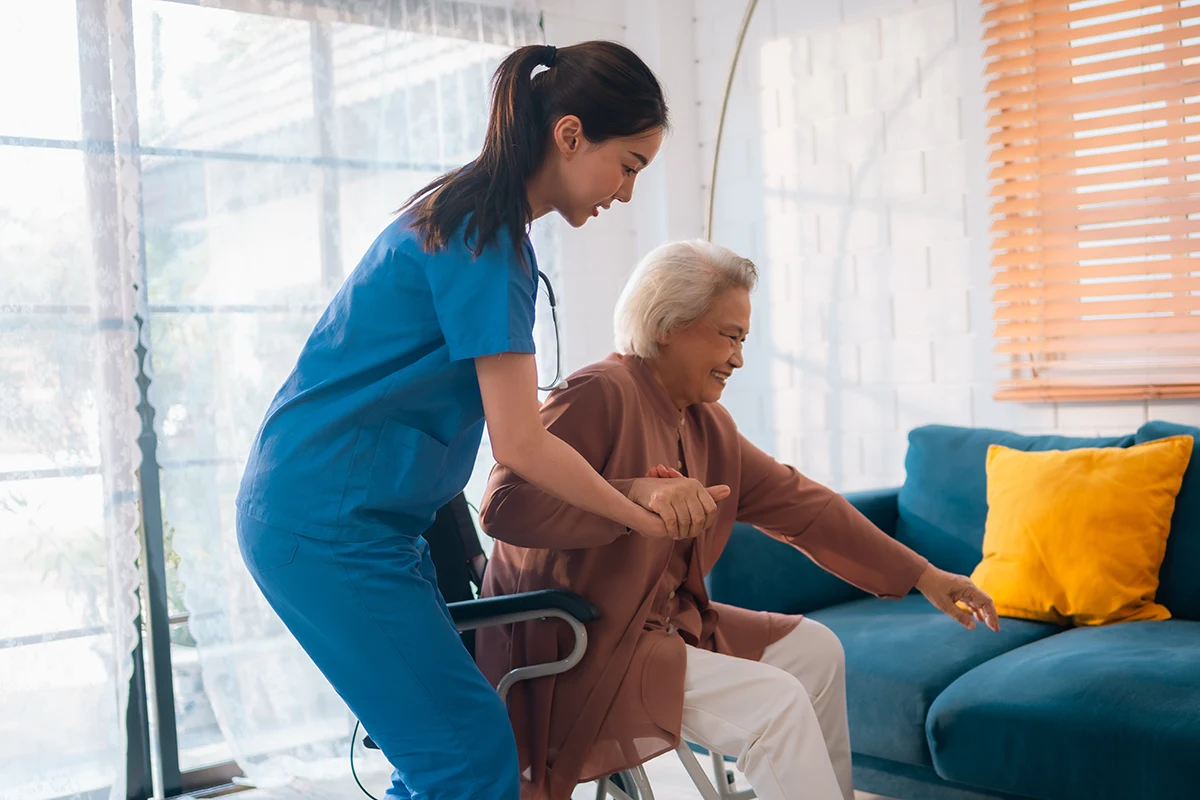 nurse helping an elderly stand up